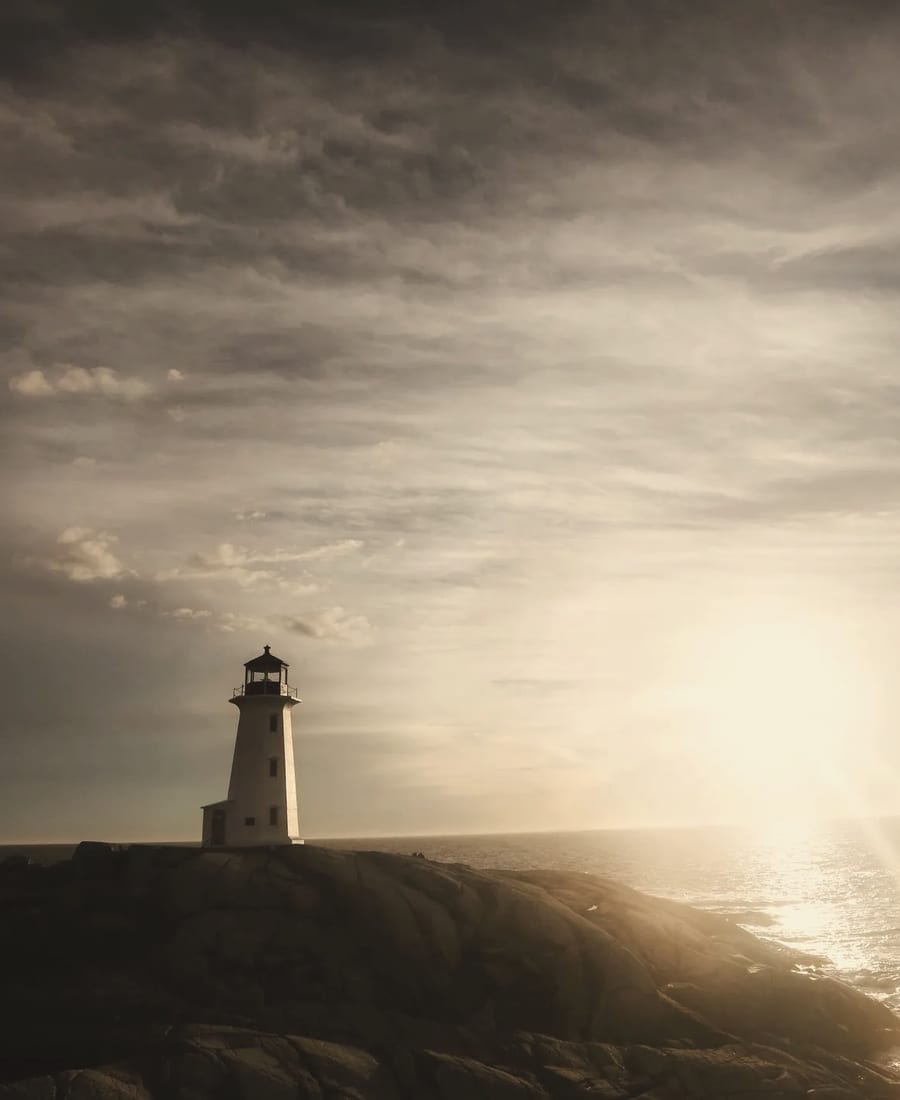 Lighthouse overlooking a calm coastal harbor